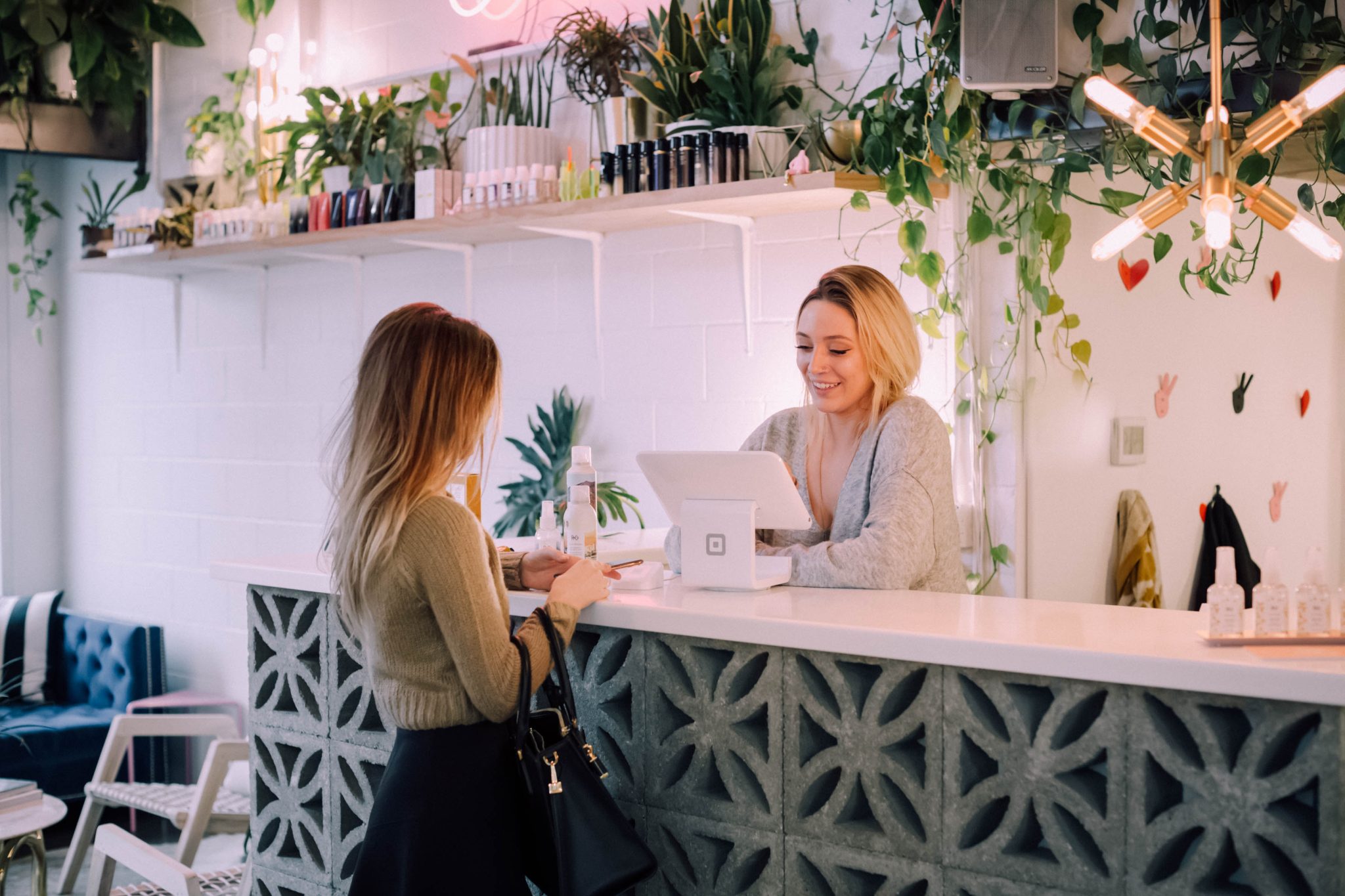 Photo pour illustrer les commerces à Seraing : Une employée derrière son comptoir discute avec une cliente.