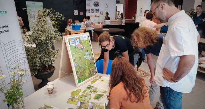 Groupe autour d'une table qui regarde un montage pendant une expo.