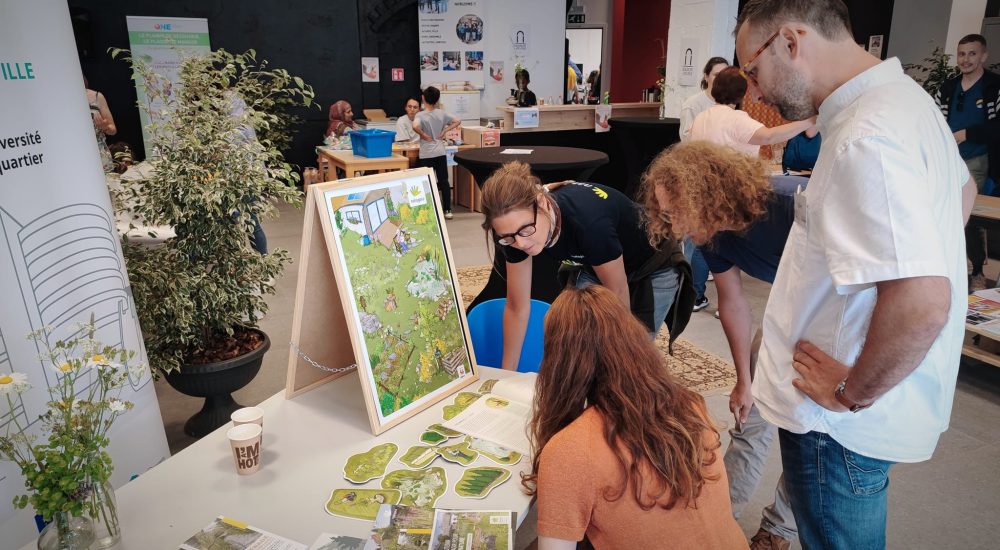 Groupe autour d'une table qui regarde un montage pendant une expo.