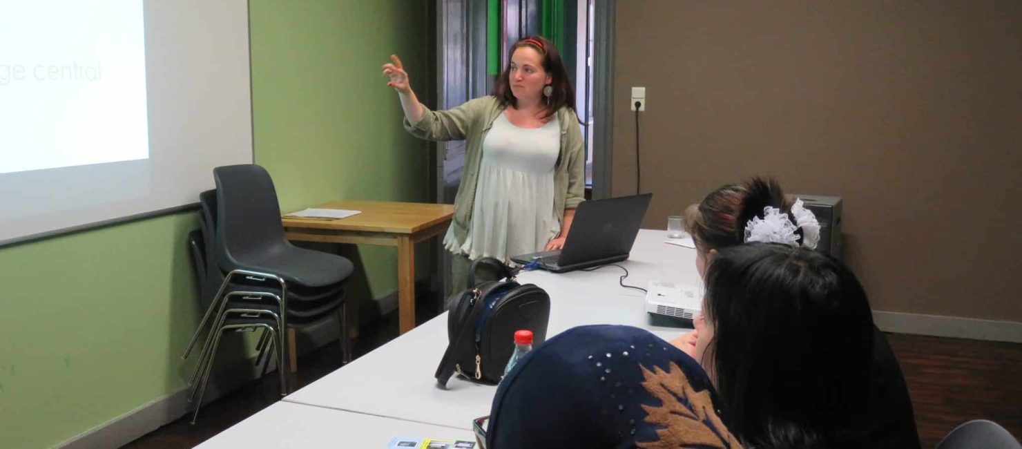 Présentation PowerPoint d'une dame face à un public.