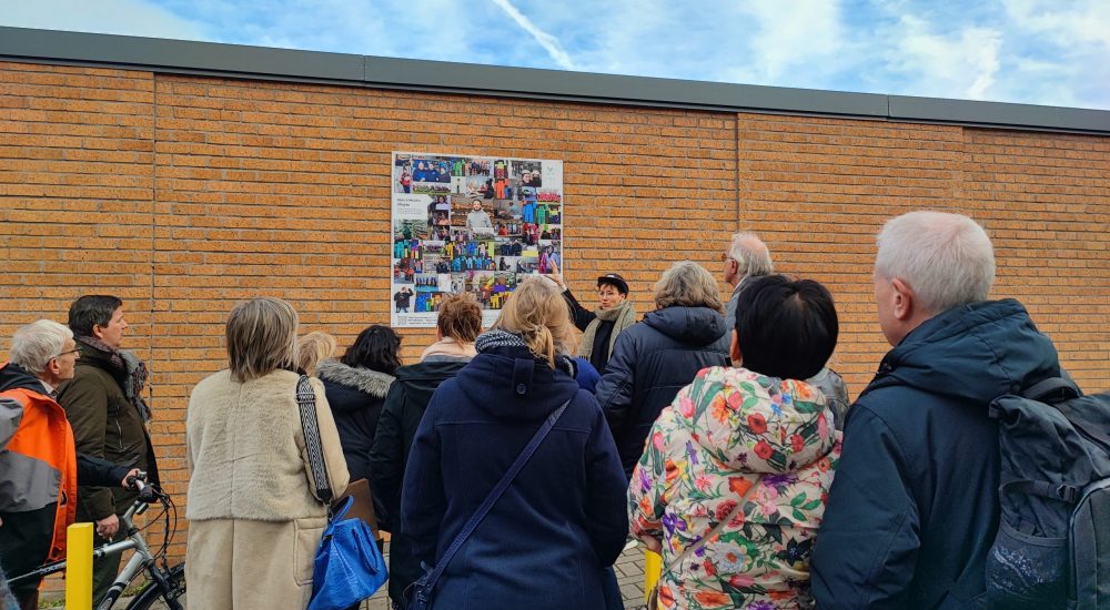 Groupe de personnes fixant une affiche au mur.