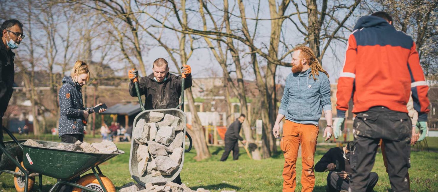 Photo d'un groupe en train de travailler en déplaçant des blocs de pierre pour le projet "A place to-be-come".